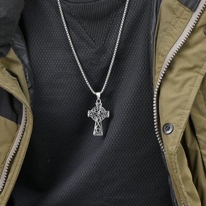 Men's silver Celtic cross necklace with knotwork pattern on black waffle knit clothing