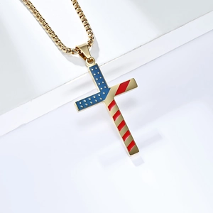 Detailed macro view of American flag cross pendant with gold box chain on white base