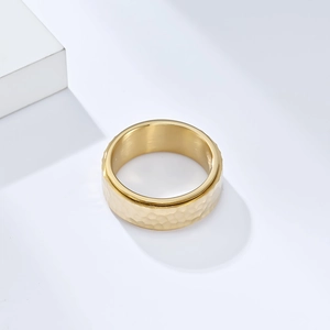 Detailed macro view of the gold hammered texture on this wide stainless steel spinner ring