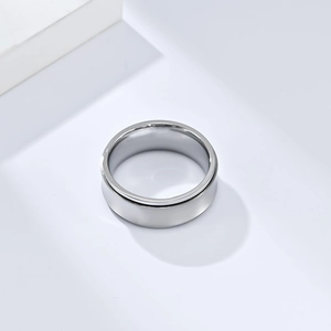Close-up of polished silver titanium anxiety spinner ring on white geometric props