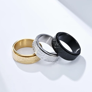 Close-up of hammered texture rings in gold, silver and black stainless steel
