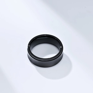 Macro detail of glossy black minimalist spinner ring with smooth reflective surface