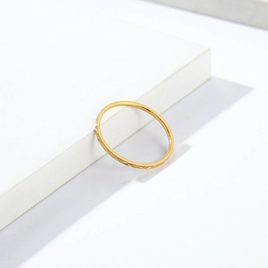 Detail of 1mm gold stackable titanium ring with a textured diamond pattern surface