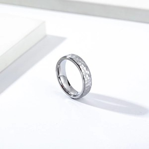 Macro detail of hammered titanium steel ring showing unique texture and polished inner band