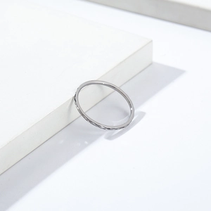 Macro shot of 1mm silver titanium ring with diamond-cut texture on white block