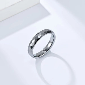 Détail d'une bague en acier tungstène de 4 mm avec surface facettée et fini gris foncé