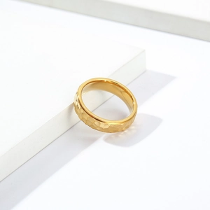 Detail of gold hammered texture ring with irregular geometric facets on a white background