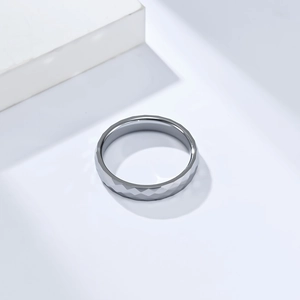 Détail macro d'une bague en carbure de tungstène de 4 mm avec surface à facettes géométriques