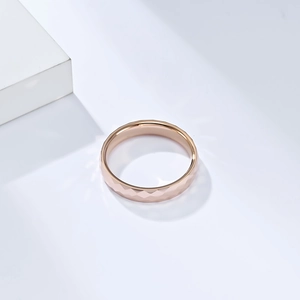 Vue macro d'une bague en tungstène or rose de 4 mm avec détails géométriques facettés