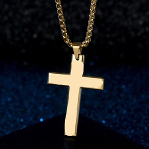 Macro shot of gold cross pendant on box chain over starry background for detail