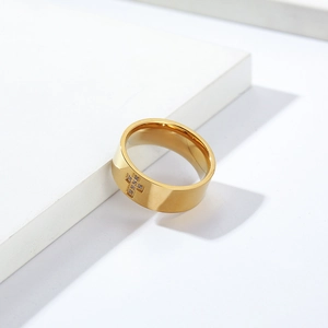 Dettaglio macro dell'anello a croce d'oro con diamanti e finitura in acciaio inossidabile