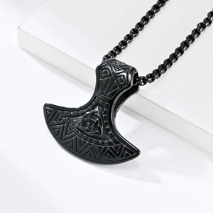 Primer plano de un colgante de hacha vikinga negro mate con nudo celta y cadena de eslabones