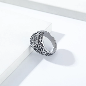 Detailed view of vintage Viking compass ring with textured surface on a stone stand