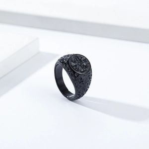 Detailed macro shot of vintage black Viking compass ring with a hammered texture finish