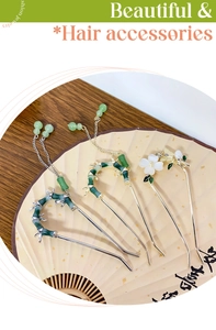 Detailed view of bamboo style hairpins with tassels on a traditional folding fan