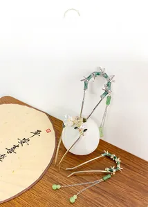 Detail of Chinese bamboo hairpin with green tassels, pearls and golden butterfly accents