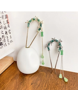 Close-up of elegant bamboo-style hair pins in gold and silver with long chain tassels