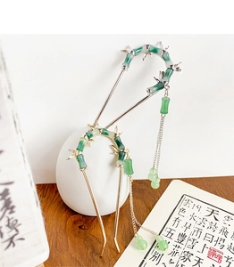 Detailed close-up of bamboo style hairpins with green faux jade beads and long tassels