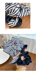 Detailed texture of blue striped and navy satin scrunchies with elegant bow on wood