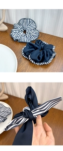 Detailed macro view of blue and white striped fabric scrunchies with elegant bow ribbons