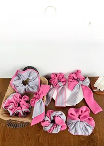 Détail d'un ensemble de chouchous en mousseline à rayures rose et menthe sur table en bois