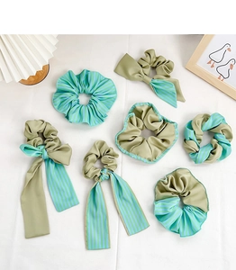 Ensemble de 7 chouchous vert olive avec rubans et tissus rayés sur fond blanc épuré