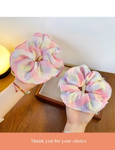 Close-up of two large plaid scrunchies in pastel colors with wrinkled fabric texture