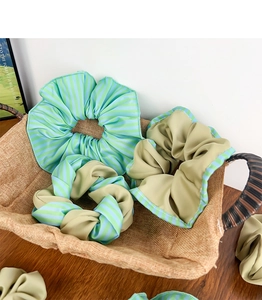 Détail de trois chouchous élégants avec des textures rayées et vert olive