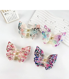 Detail view of ink painting butterfly hair claws in diverse floral and marble patterns