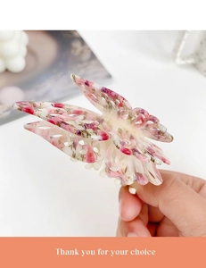 Macro detail of butterfly hair claw clip with double-layer hollow wings and floral patterns