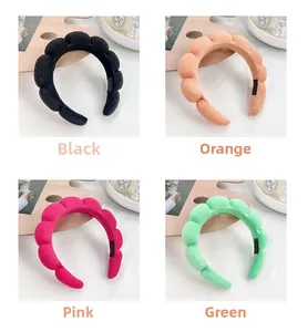 Détail de serre-têtes bouffants en noir, orange, rose et vert avec un tissu texturé doux