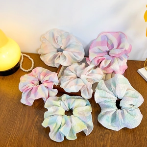 Set of six large plaid seersucker scrunchies in sweet pastel colors on a wooden table