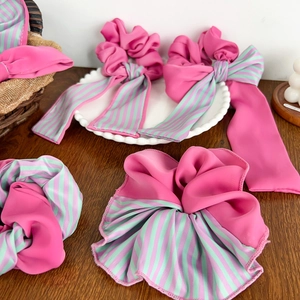 Ensemble de chouchous rose vif et ruban à rayures sur une table en bois rustique