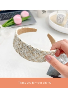 Gros plan d'un serre-tête large en paille tressée à carreaux avec texture naturelle