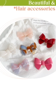 Detail view showing six colorful acetate bow hair clips in solid and marble patterns