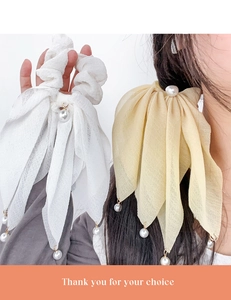 Détail de chouchous nœuds en maille avec perles fantaisie en beige et jaune