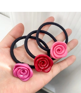 Detail von Acetat-Rosen-Haargummis in Rot und Rosa mit elastischen geflochtenen Bändern