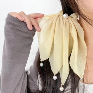 Élastique à cheveux élégant en mousseline jaune avec perles sur cheveux noirs