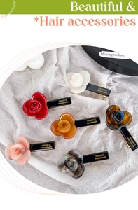 Detailed macro view showing six floral acetate hair clips with gold handmade lettering