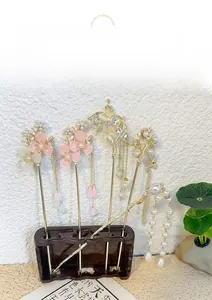 Detail of five vintage Chinese hairpins with golden tassels and delicate plum blossoms