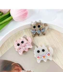 Set of three cute cat-shaped acetate hair clips with heart rhinestones on a wooden tray