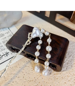 Detailed close-up of a vintage Chinese style hair pin with elegant pearl tassels and plum motif