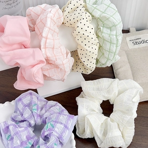 Lot de 6 chouchous en tissu aux motifs pastel sur un support de présentation en T blanc