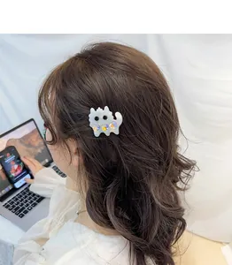 Cute white acetate cat hair clip with colorful rhinestone hearts worn on wavy hair