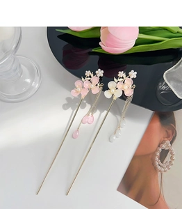 Detailed close-up of pink and white plum blossom hairpins with elegant metal tassels