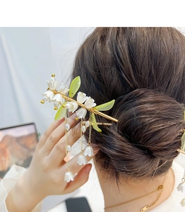 Dettaglio della forcina per capelli mughetto con nappe di perle e finitura dorata