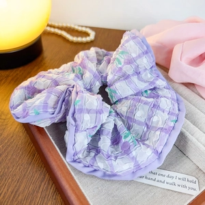 Chouchou chic à carreaux mauves et fleurs vertes avec texture plissée sur bois chaleureux