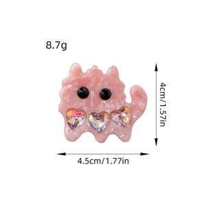 Pink marbled monster hair clip with heart crystals and size markings on white background