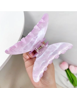 Detailed macro of a purple marble butterfly hair claw clip with strong metal spring