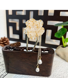 Macro detail of alloy peony hair pin with layered cream petals and hanging pearl tassels